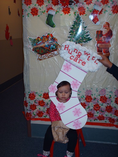 A child holding a sign saying hung with care